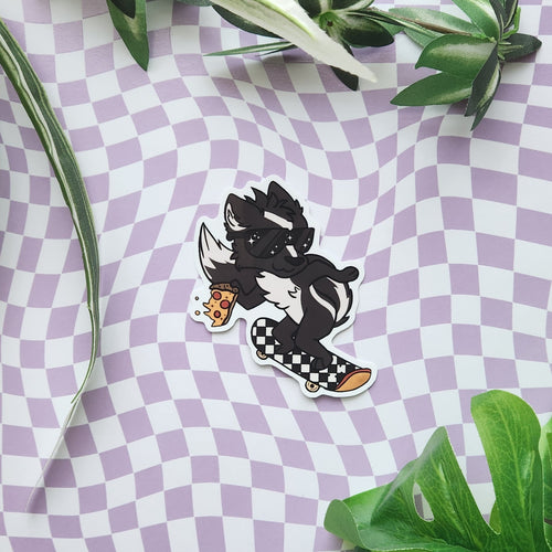 A die-cut sticker featuring a cartoon skater character in black and white with a checkered skateboard and holding a slice of pizza, placed on a purple and white checkered surface with green leaves around the edges.