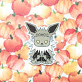 A die-cut sticker featuring a cute cartoon character with large pointed ears, yellow eyes, and black-and-white striped legs, placed on a watercolor pumpkin patterned background.