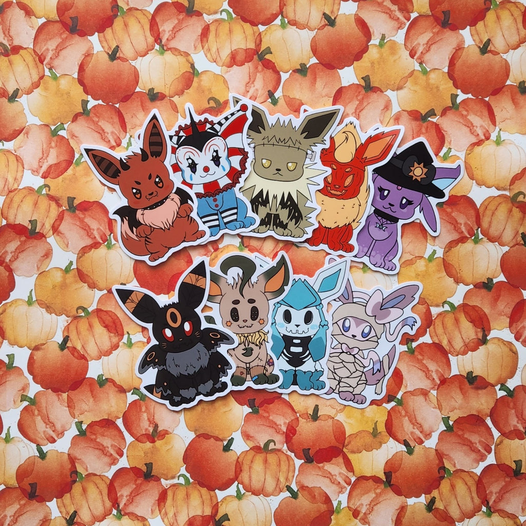 A set of eight die-cut vinyl stickers featuring various foxes in Halloween costumes, arranged on a white background with a repeating pattern of orange pumpkins.